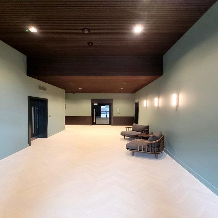 Commercial lobby decorated in sage green with timber ceiling, London