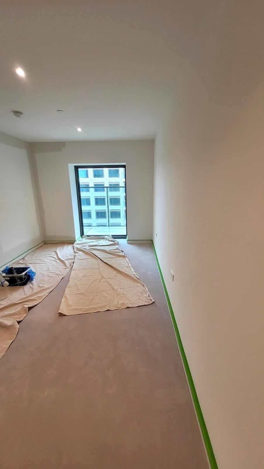 Living room sheeted and masked ready for interior painting in London