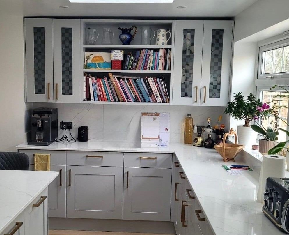 Kitchen cabinets resprayed in light grey with gold handles